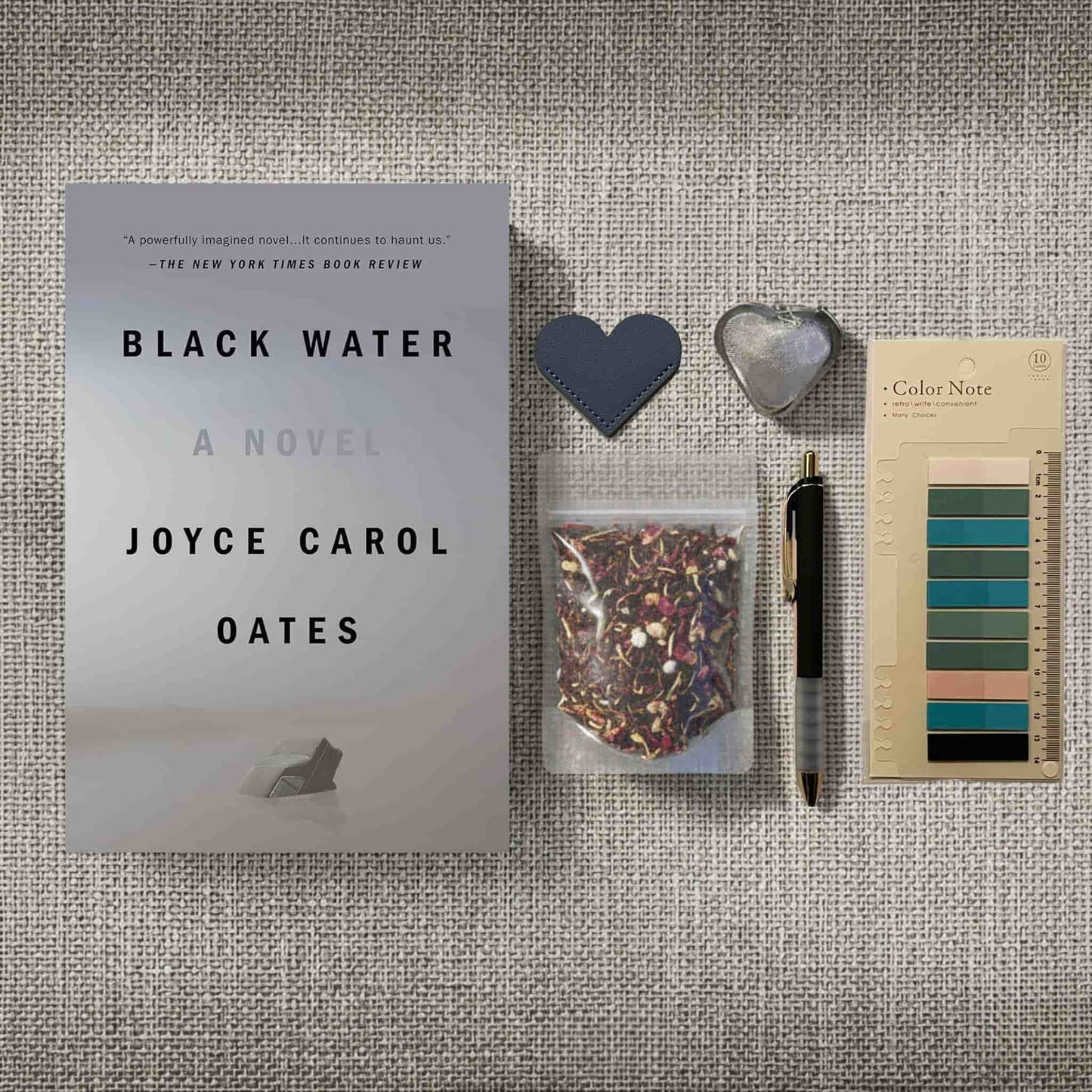Dark academia bookish flatlay with 'Black Water' by Joyce Carol Oates, aesthetic color palette swatches, and reading accessories for a cozy retreat.