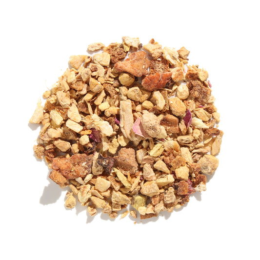 Top-down view of Rejuvenation Lemon Ginger Herbal loose-leaf tea blend displaying coarse pieces of dried ginger, citrus peel, licorice root, and pink rose petals arranged on a white background.