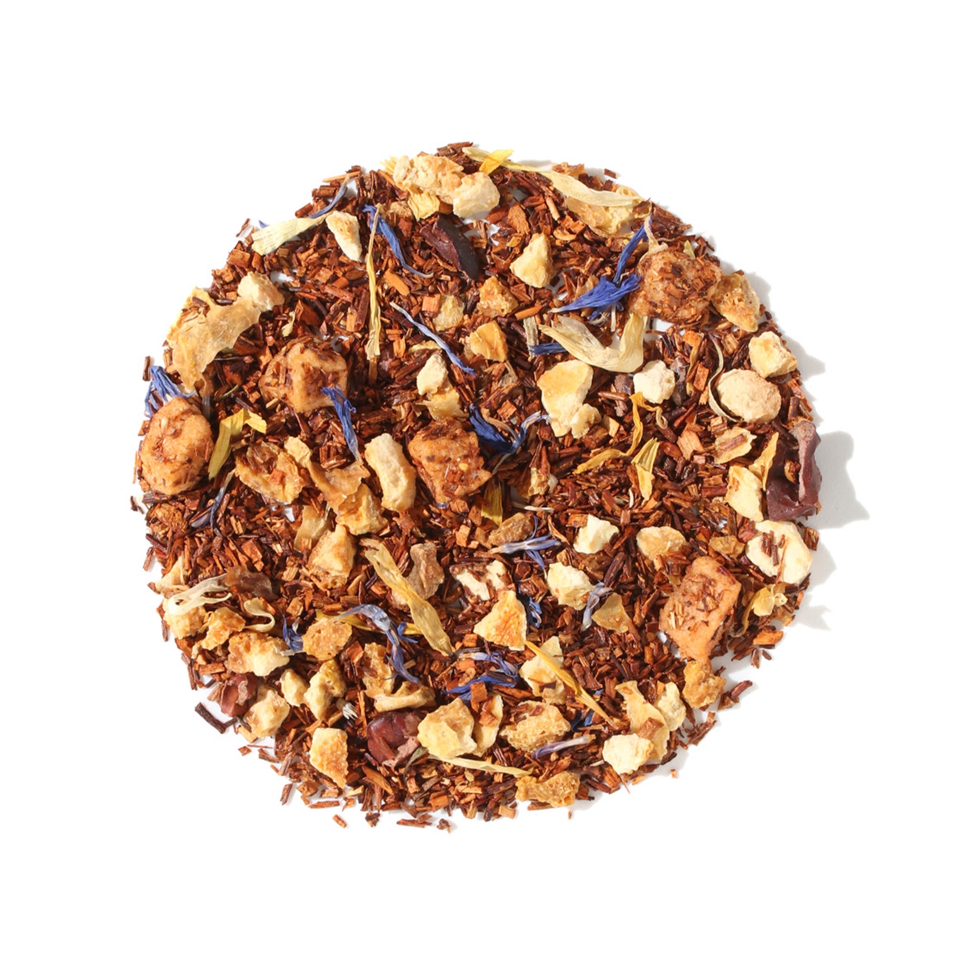 A close-up, overhead view of Plum Deluxe Soul Warmer Herbal Tea arranged in a neat circle against a white background. The loose leaf blend features fine red rooibos needles mixed with visible chunks of apple, dark cocoa nibs, and colorful pops of calendula and cornflower petals.