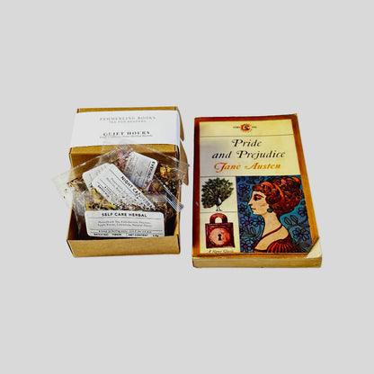 Open Quiet Hours tea flight box displaying four loose-leaf pouches fanned inside, resting beside a vintage Pride and Prejudice paperback.