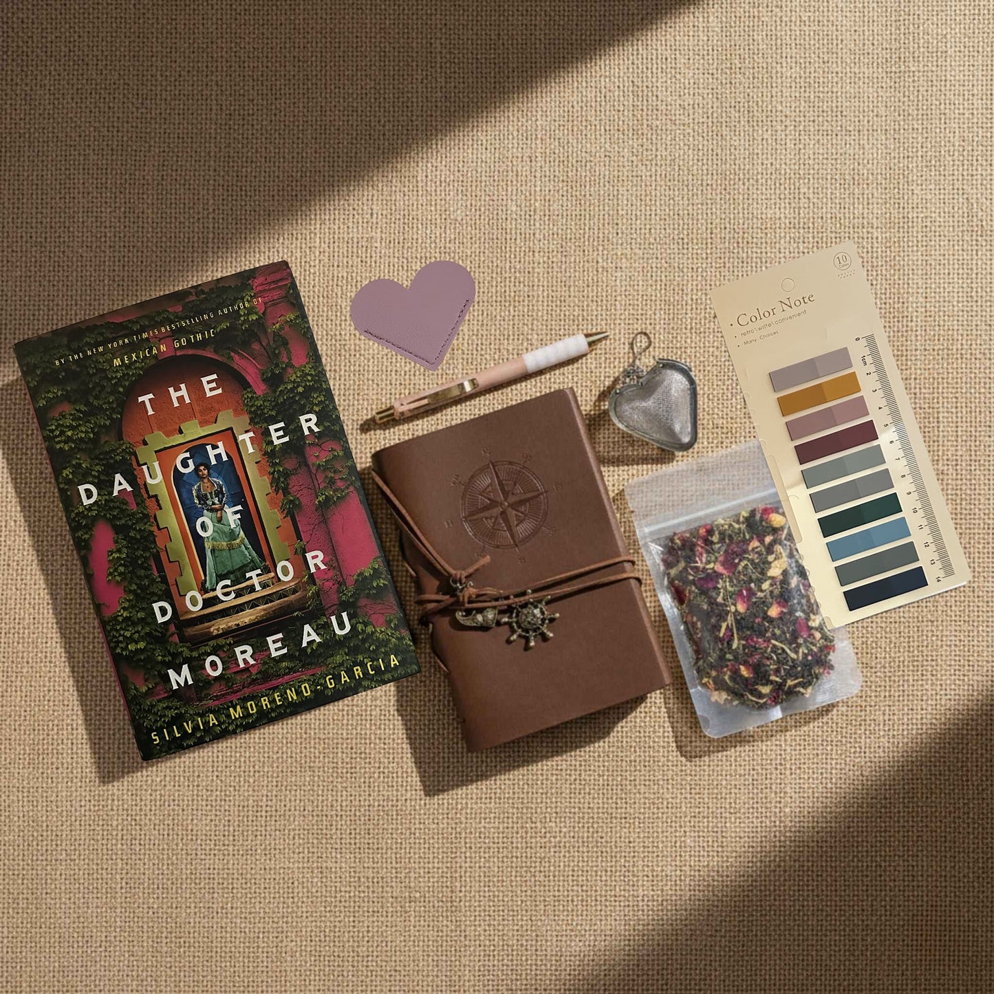 Product image for the Ultimate Literary Collection of The Daughter of Doctor Moreau. Includes tea accessories, a leather-wrapped field journal, and curated stationery. This Fehmerling Books bundle highlights themes of 19th-century Mexico and scientific experimentation, offering a complete immersive gifting experience for fans of historical sci-fi and gothic romance.