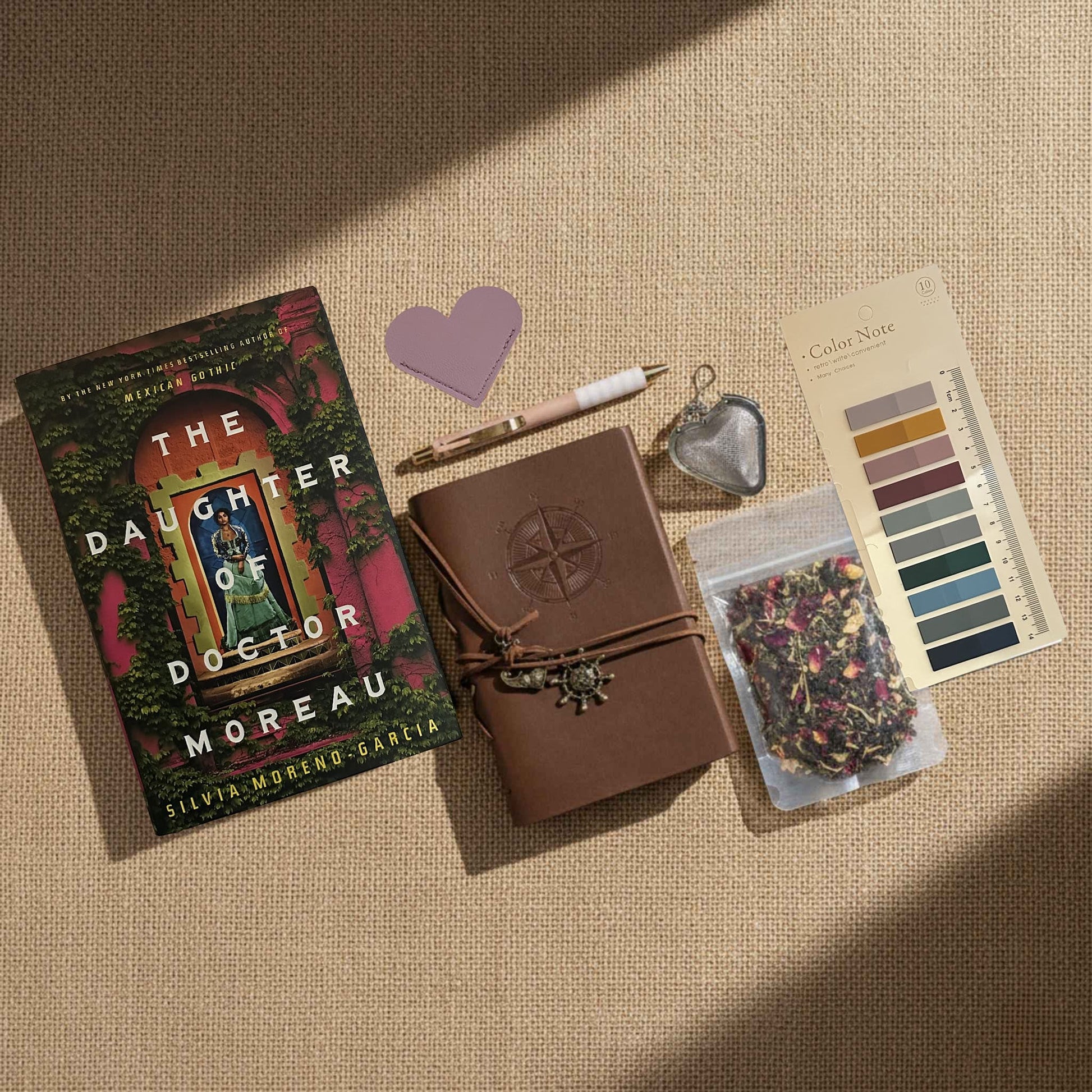 Product image for the Ultimate Literary Collection of The Daughter of Doctor Moreau. Includes tea accessories, a leather-wrapped field journal, and curated stationery. This Fehmerling Books bundle highlights themes of 19th-century Mexico and scientific experimentation, offering a complete immersive gifting experience for fans of historical sci-fi and gothic romance.