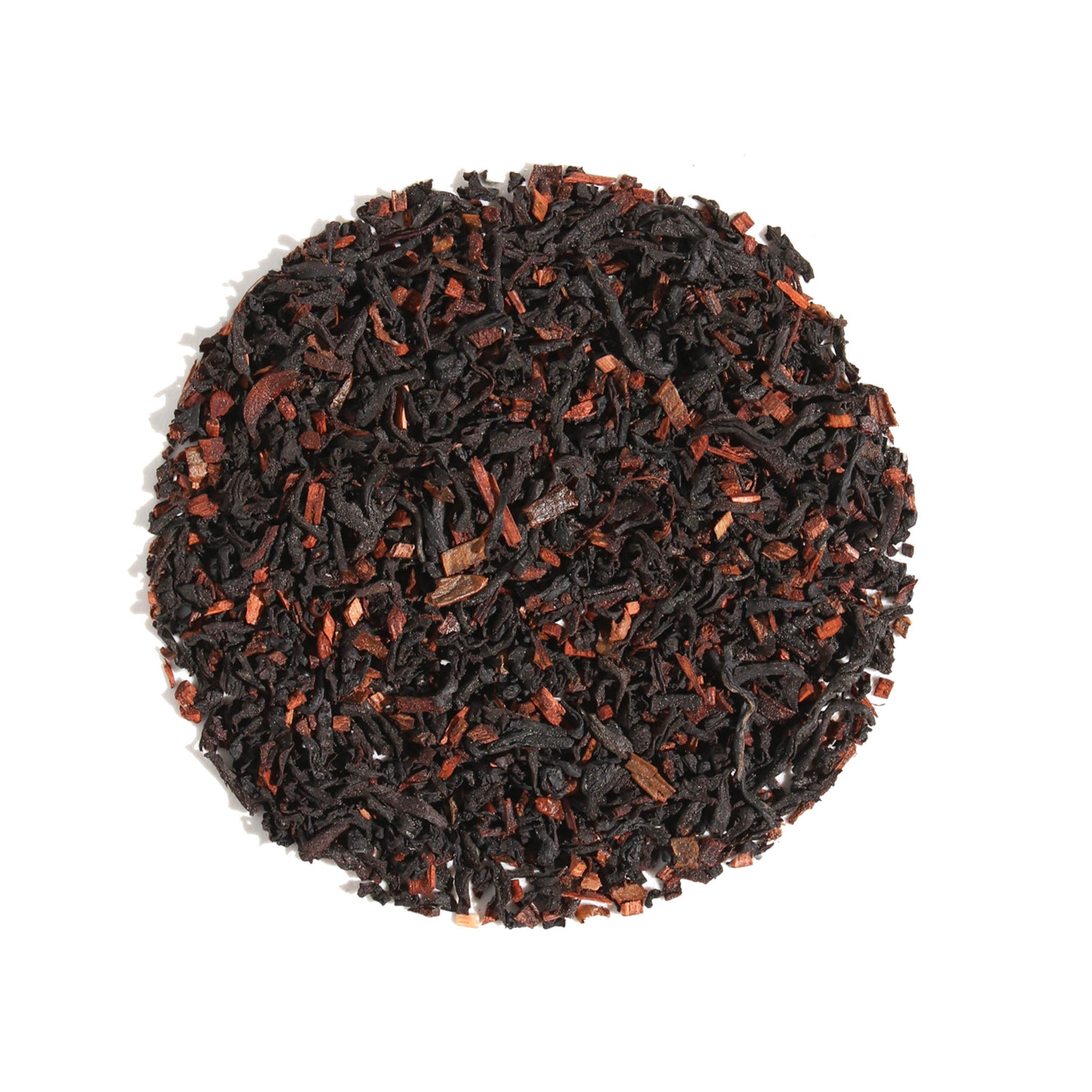 Top-down view of Vanilla Latte Cardamom Creme Black Loose Leaf Tea arranged in a circle on a white background, displaying dark black tea leaves blended with aromatic cardamom and warm spice pieces.